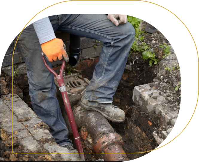 A person with orange gloves is digging in the ground